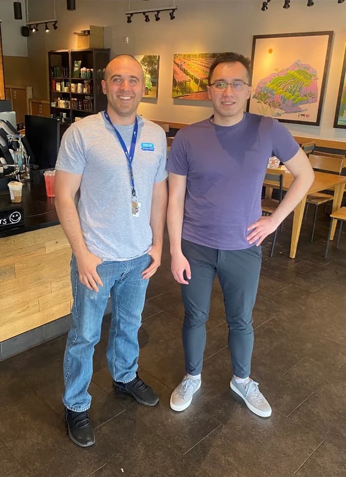 Jim Peterson standing with another software community member inside a café.